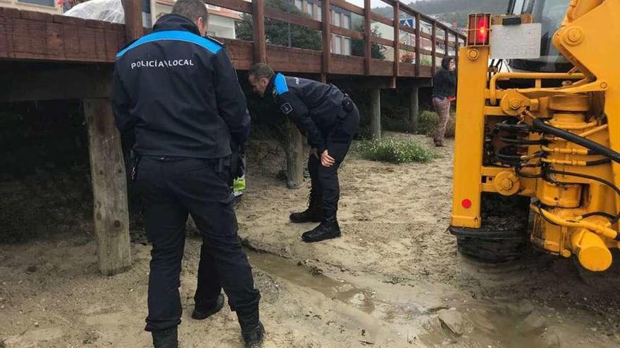 La Policía Local revisa los restos de vertidos a la playa de San Cibrán, el pasado 19 de octubre. // G.Núñez