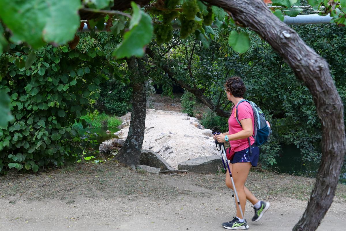 Una mujer observa la presa de Cabanelas.