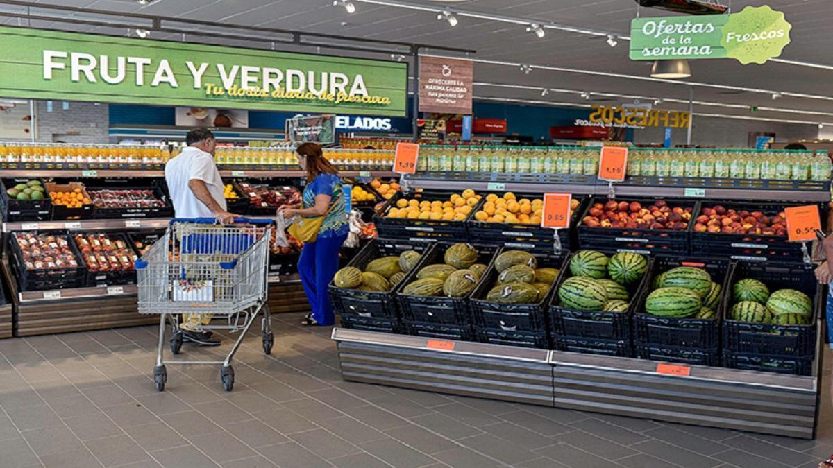 Unos clientes de un supermercado recorren la zona de frutería