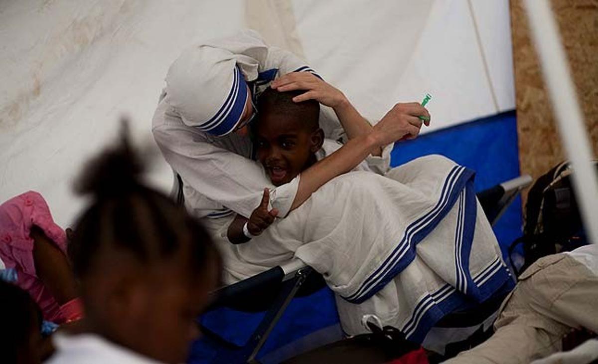 Una religiosa de la Congregació de les Missioneres de la Caritat abraça un dels 318 nens haitians adoptats per ciutadans francesos, a Port-au-Prince (Haití). El primer dels dos avions que traslladaran d’Haití a França els nens arribarà demà a París.