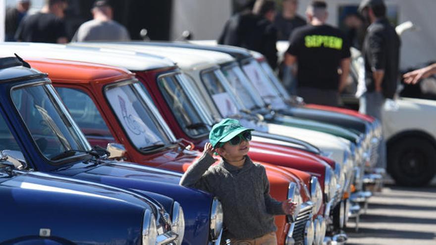 Un niño posa ante unos vehículos clásicos en Cheste