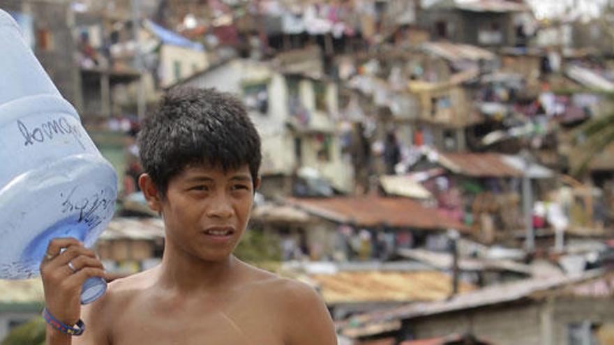 Un joven recoge agua en Filipinas.