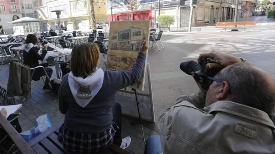 Arriba, una de las participantes ultima su obra; abajo, la plaza de la fruta, que acogió el acto.