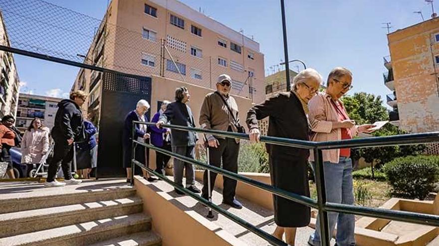 Colas de ciudadanos esperando a depositar su voto en un colegio electoral de Palma.