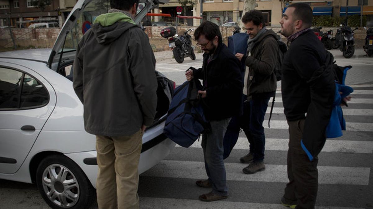 Un grupo de jóvenes que comparten coche cargan el maletero.