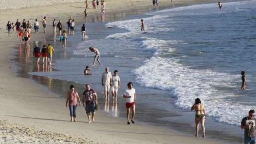 Bañistas y paseantes por la orilla de la playa de Samil en la tarde de ayer. // J. Lores