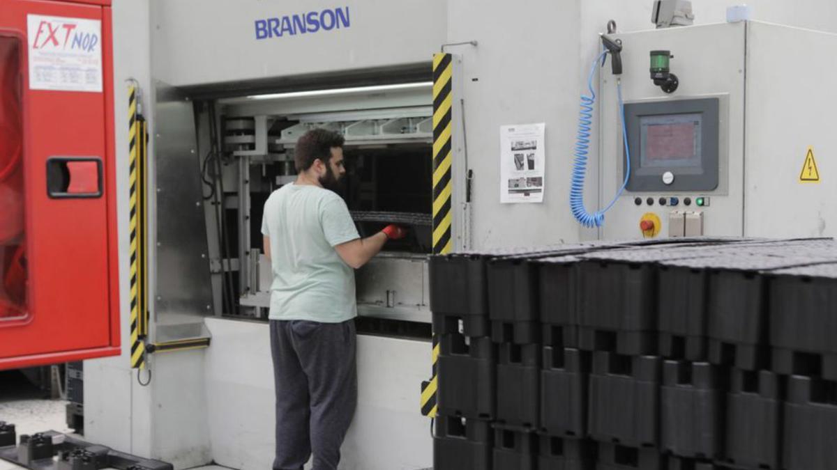 Un trabajador introduciendo palés en un horno. 