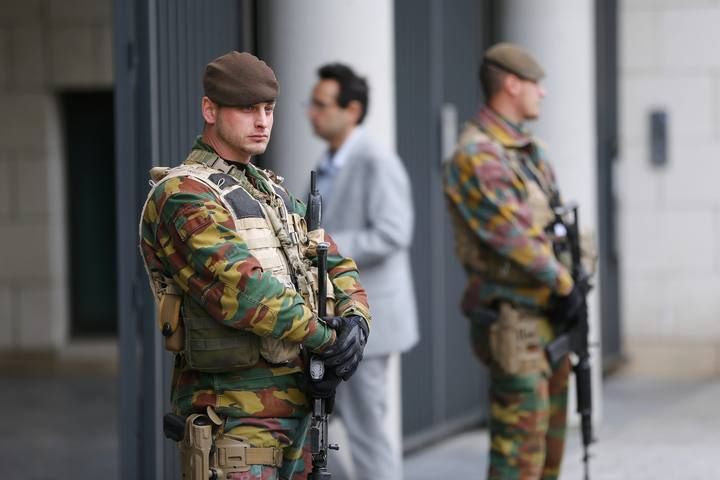 Armed soldiers stand guard outside the courthouse where suspects are expected to be questioned in the fatal shootings in Paris on Friday, in Brussels