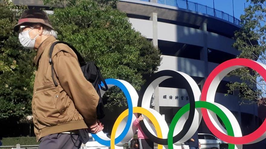 Un hombre paseo junto a los anillos olímpicos instalados en Tokio.