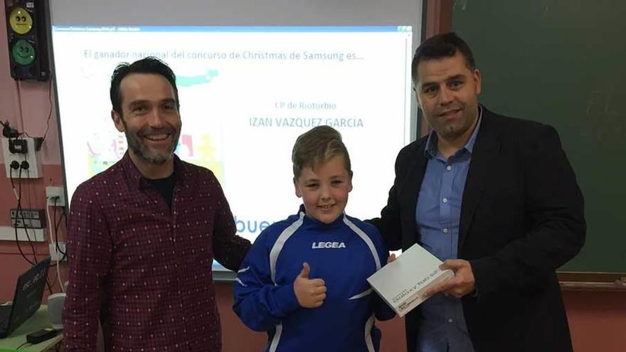 Izan Vázquez recibe la tablet de manos de los responsables de Samsung e INTEF tras ganar el concurso de postales.