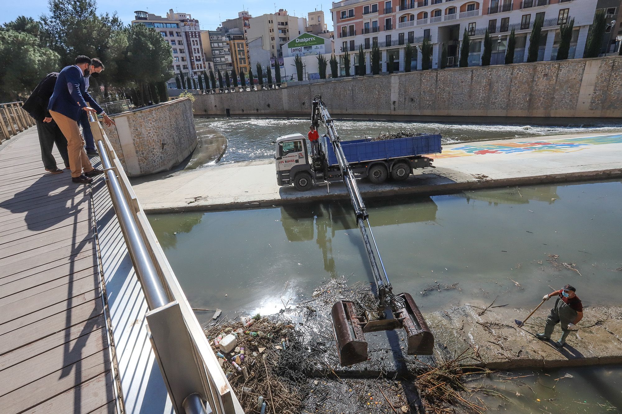 Aparicio, Mérida y Mompeán observan la limpieza del azud del río desde una pasarela