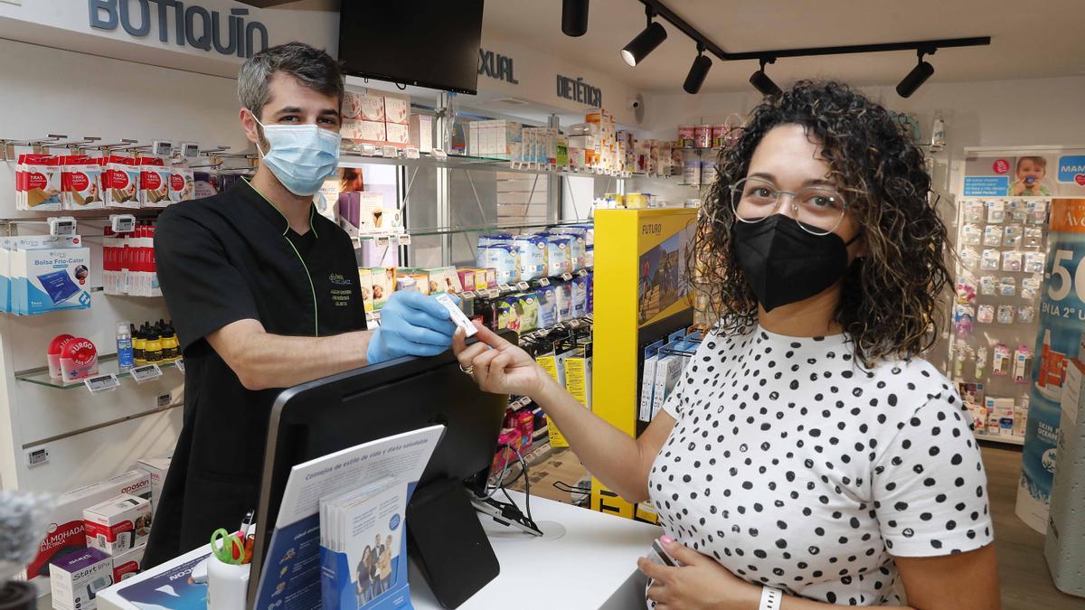 Una clienta recogiendo el test para hacerlo en la farmacia López Amil, de Vigo