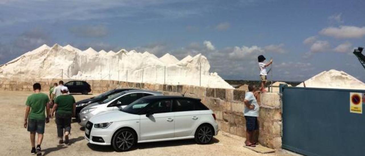 Turistas en el nuevo aparcamiento habilitado por la empresa &#039;campanera&#039; junto a las llamativas montañas de &#039;oro blanco&#039;.