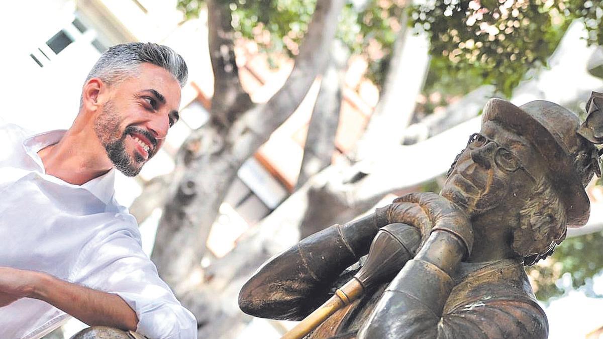 El concejal de Fiestas, Javier Caraballero, junto a la escultura de Enrique González, el 'padre de las murgas'.