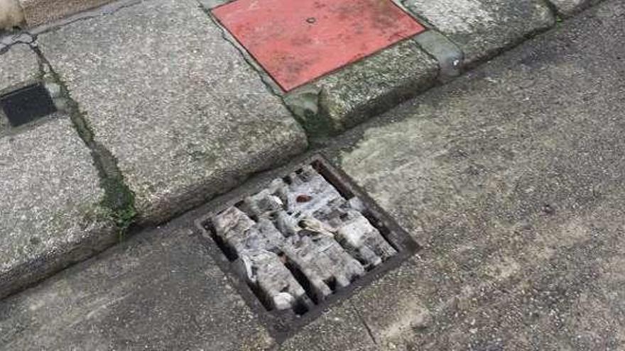 Restos de papel y residuos de fecales en un sumidero, ayer, en Betanzos.