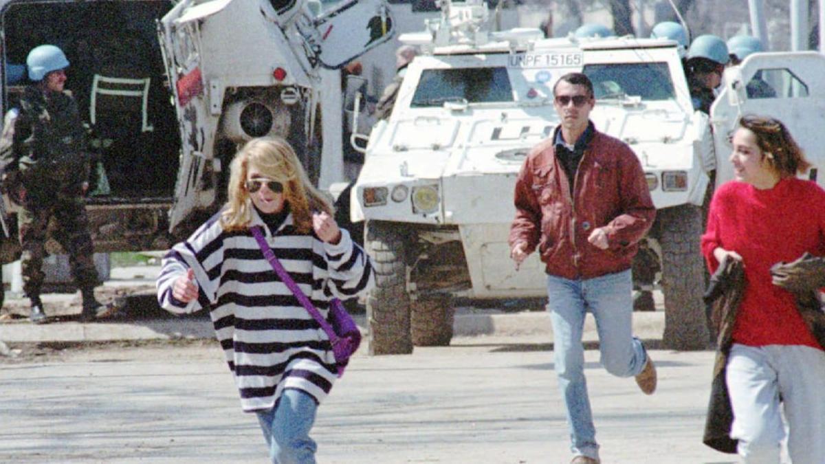 Civiles corren en la conocida como avenida de los francotiradores de Sarajevo, protegidos por un tanque de la ONU, en abril de 1995.