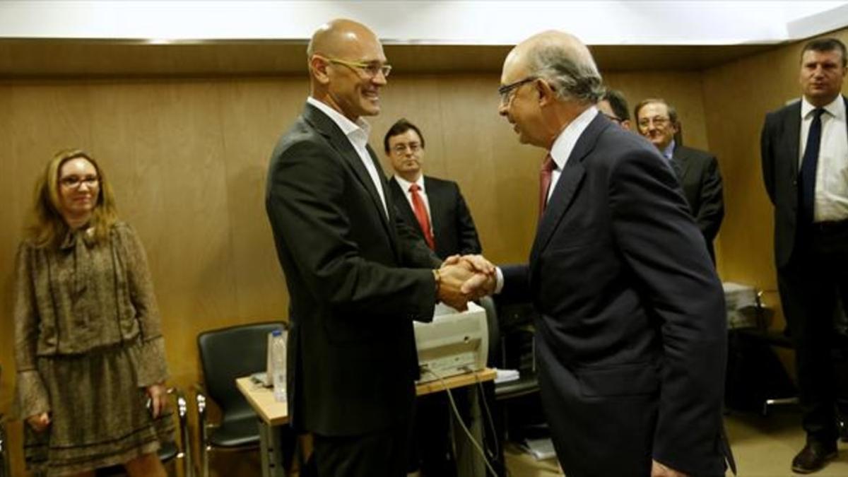 CONEXIÓN Raül Romeva, 'conseller' de Relacions Exteriors, estrecha la mano del ministro Cristóbal Montoro, ayer en Madrid.