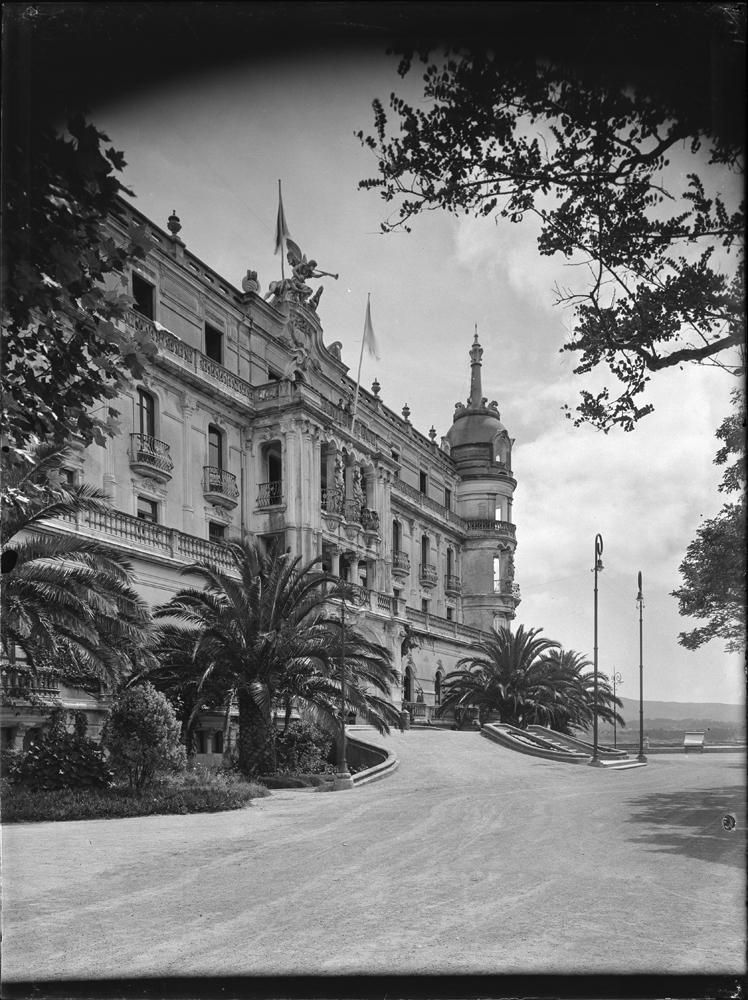 a Toja. Hotel [Vista lateral de la entrada principal con estatua alada con trompeta en lo alto. Pisos abalconados, siendo en el central balcones individuales redondeados. Banderas en la fachada 1929-1936.jpg