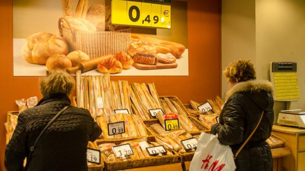 Dos mujeres comprando pan en un supermercado.