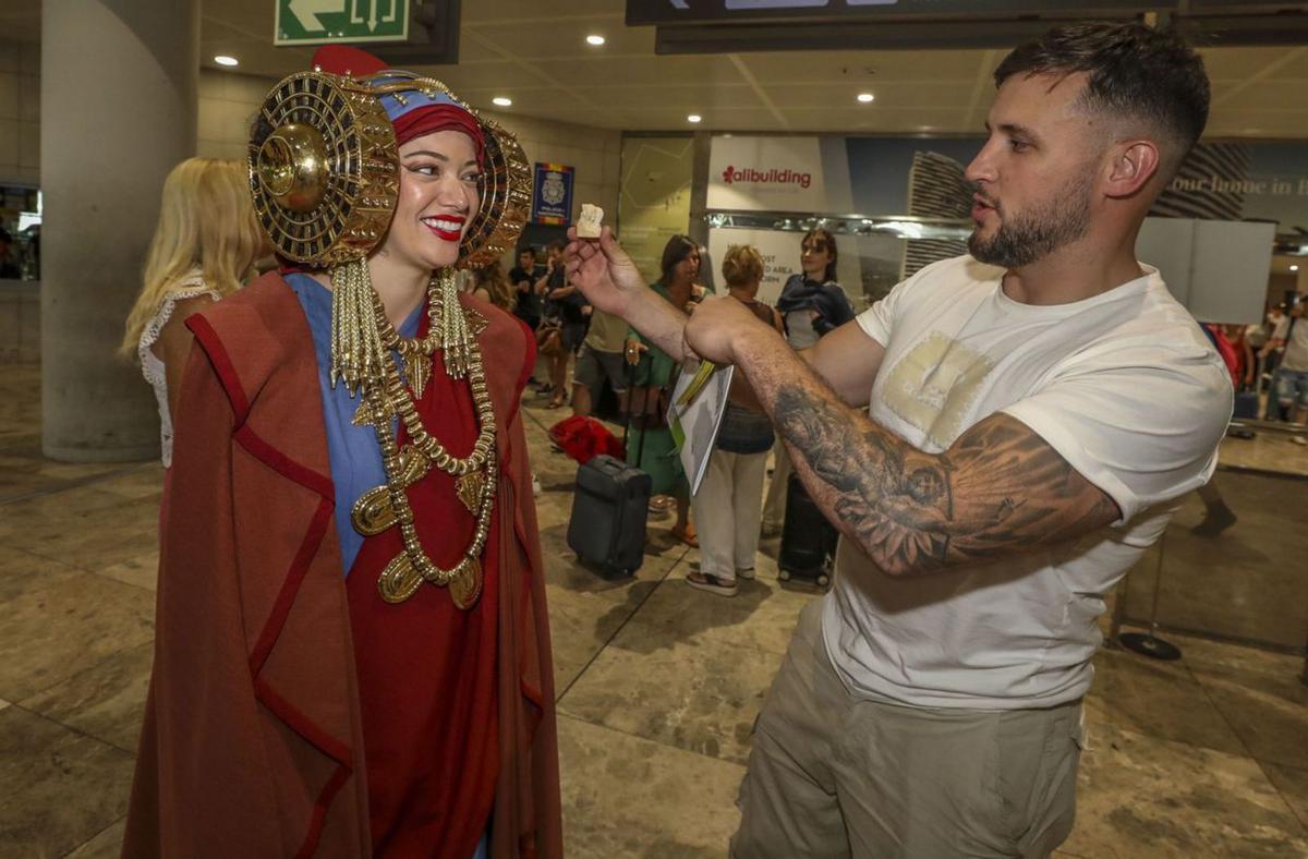 Dos imágenes de la Dama Viviente ayer en el aeropuerto donde repartió recuerdos y con una sonrisa se fotografió con los turistas. | ANTONIO AMORÓS