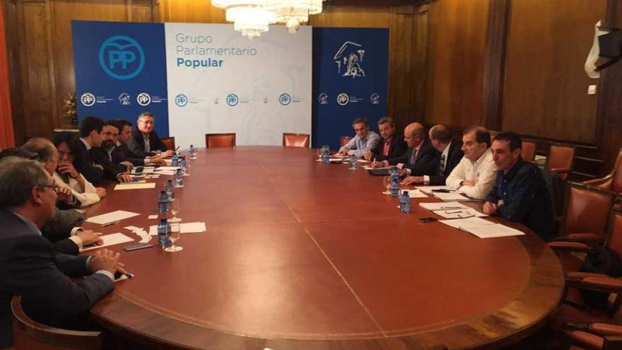 La reunión de ayer entre los diputados populares, a la izquierda, y los sindicatos y la patronal.