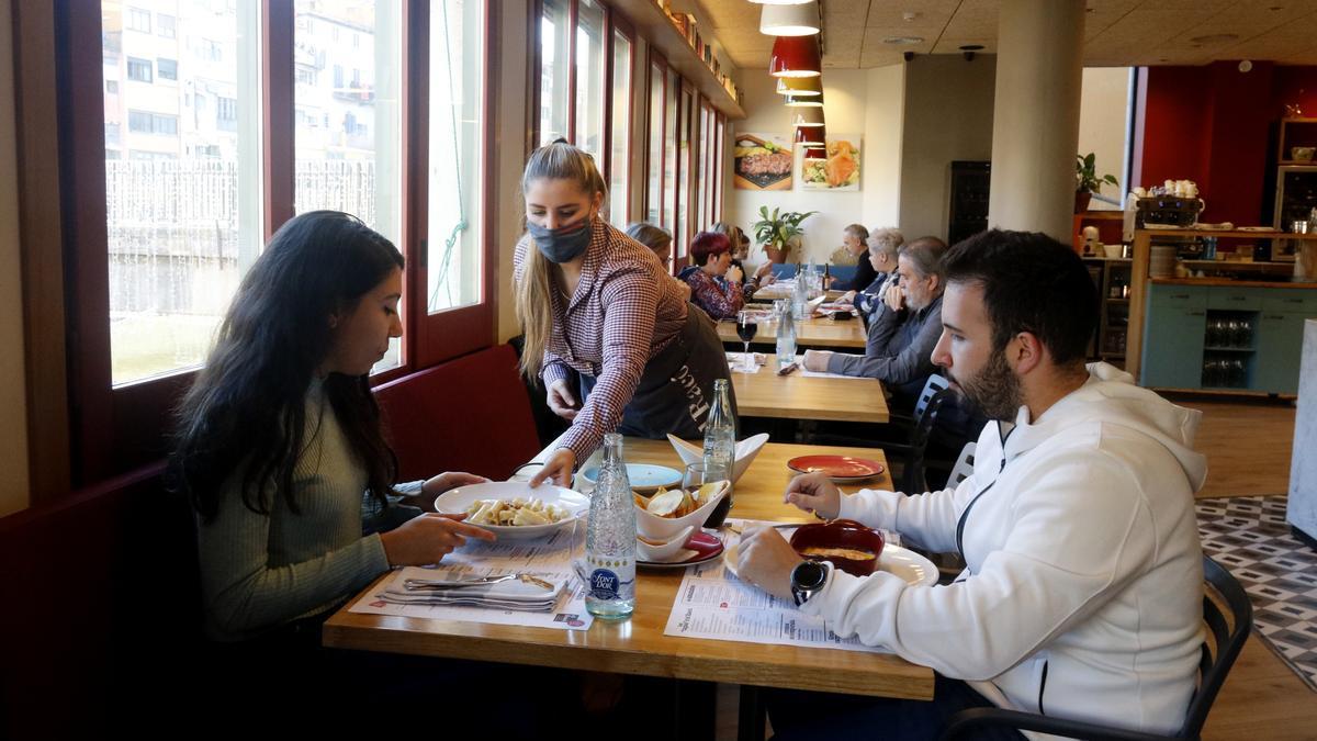 Una cambrera serveix un dinar a una parella al restaurant &#039;El racó&#039; de la plaça Independència de Girona