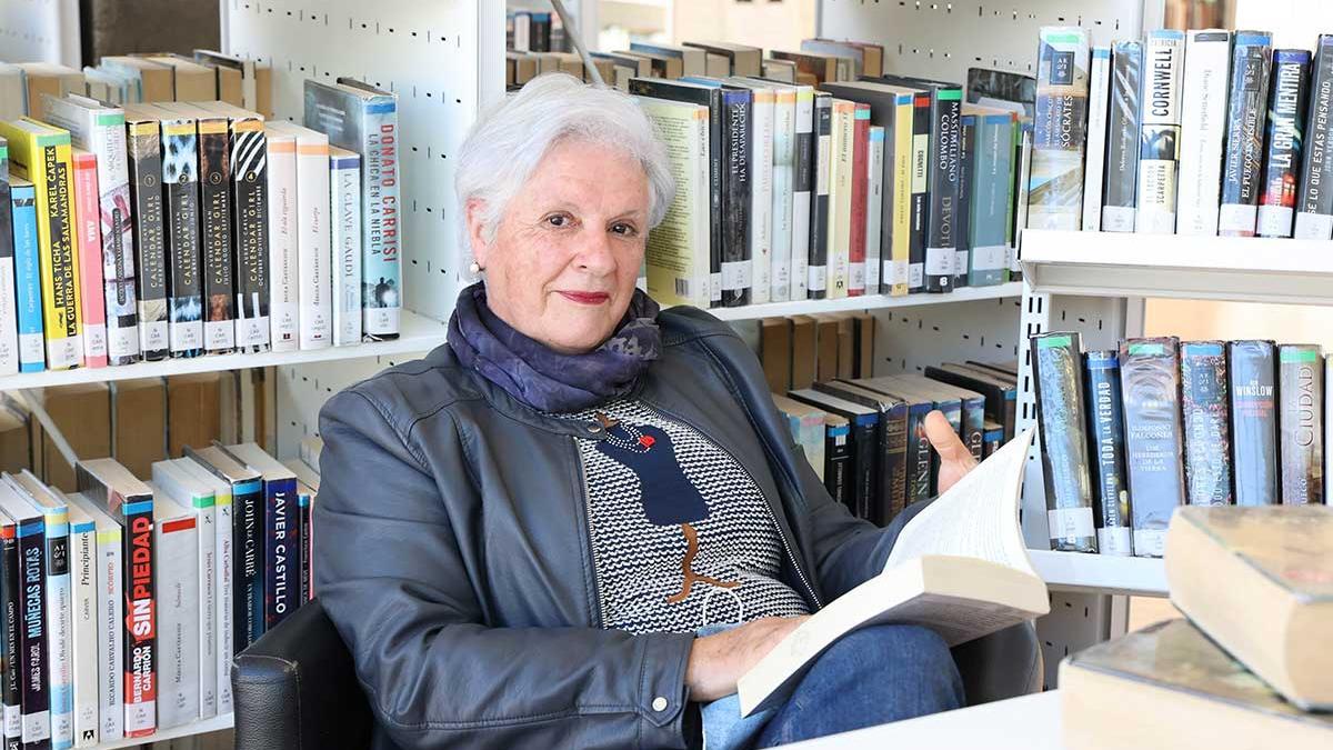 Luisa Fernández Lago en la biblioteca con uno de los más de cien libros que devora al año.