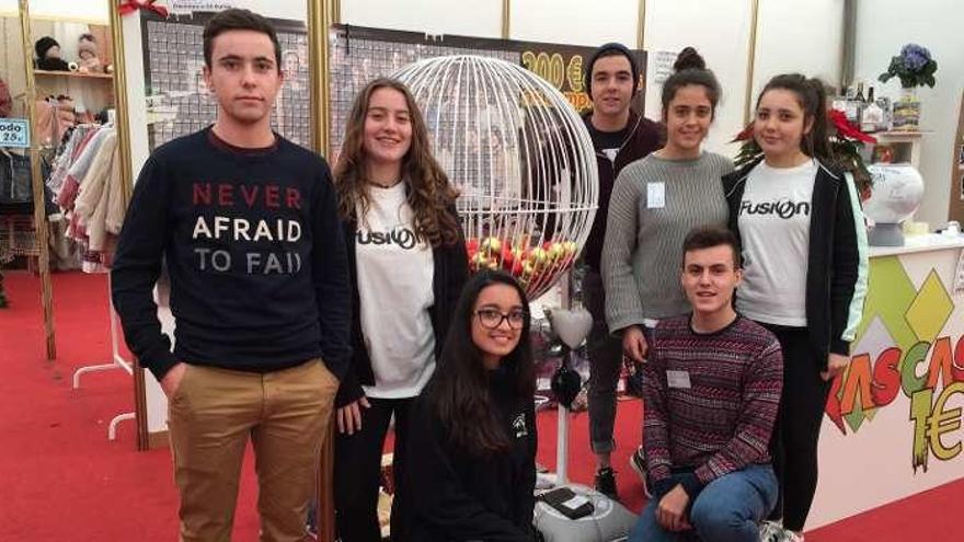 Arriba, la tómbola del viaje de estudios de 1.º de Bachillerato del Instituto de Cangas de Onís. Sobre estas líneas, el stand de La Llongar.