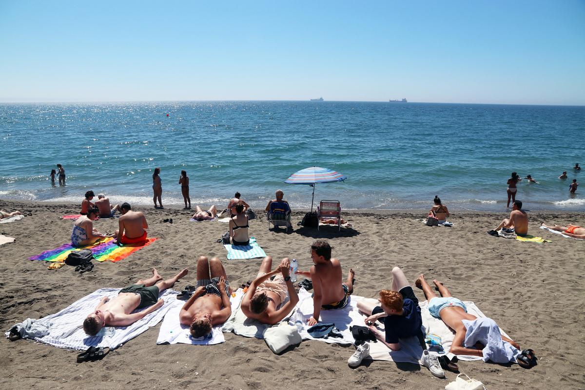 Bañistas y turistas disfrutan de un día en la playa de La Malagueta, en Málaga.