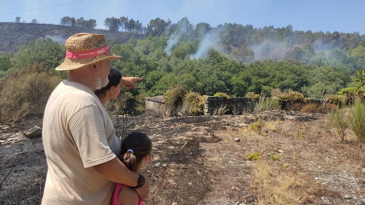 Camilo y dos menores miran la zona afectada por el fuego en Fondo de Vila, Boborás.