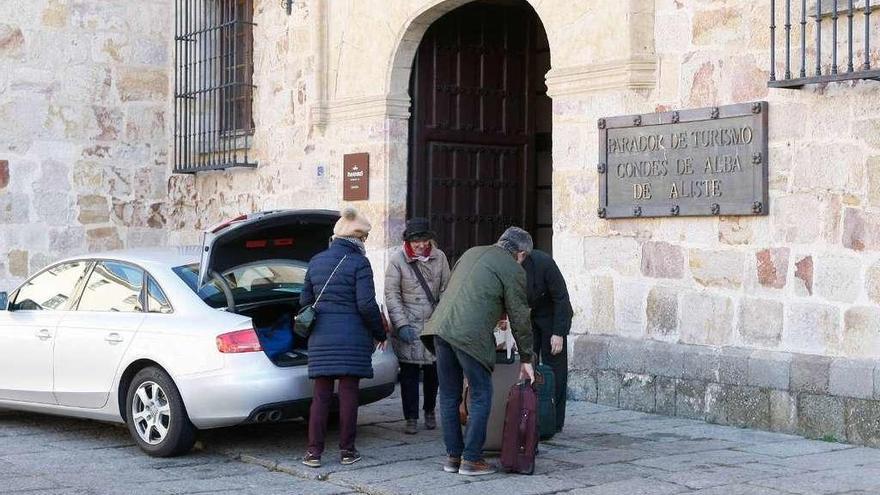 Varios turistas descargan sus maletas en el Parador.