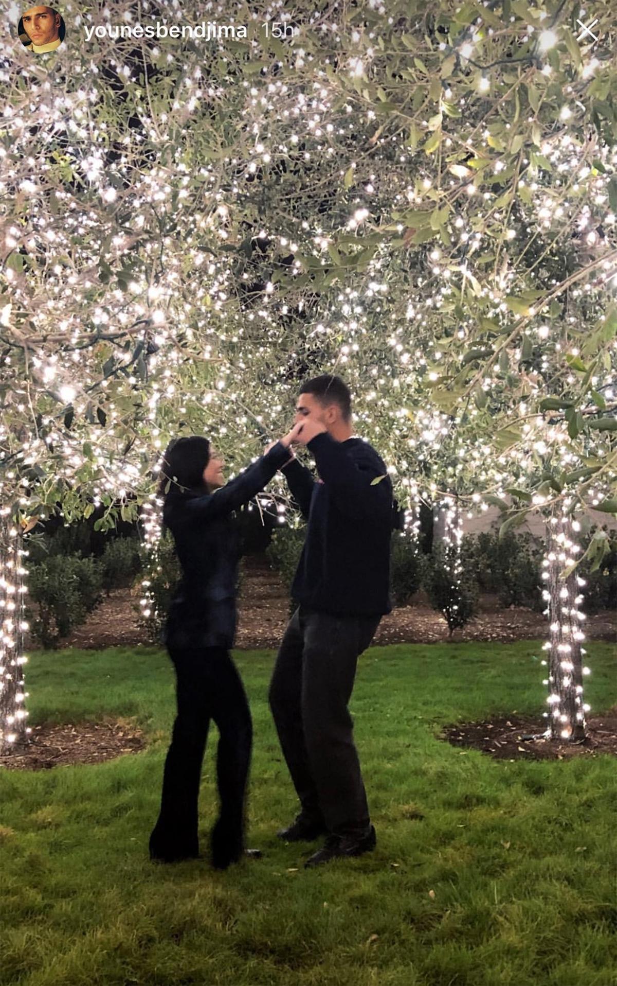 Younes y Kourtney bajo árboles de luces