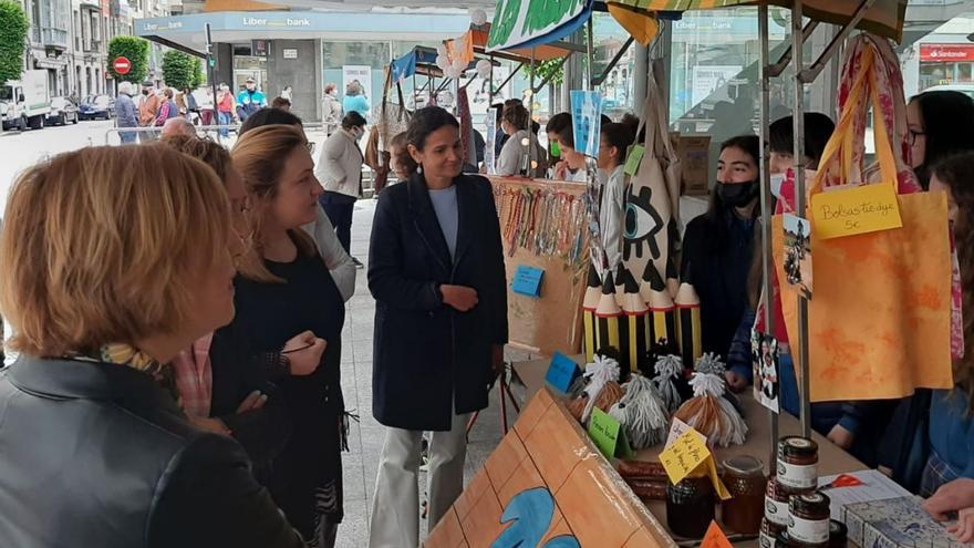 La consejera Lydia Espina, tercera por la izquierda, acompañada por personal de Valnalón, en una visita a un mercado de cooperativas escolares en Pola de Siero.