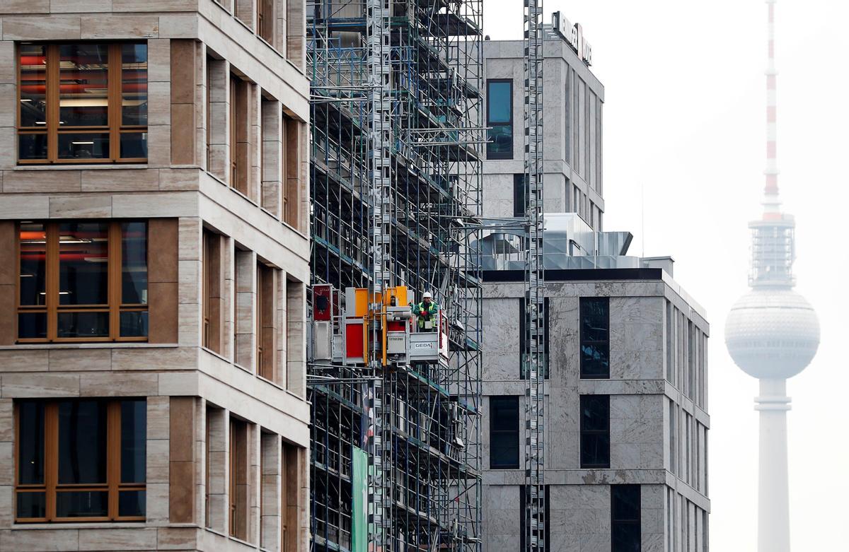 Un albañil sube en un ascensor en una obra.