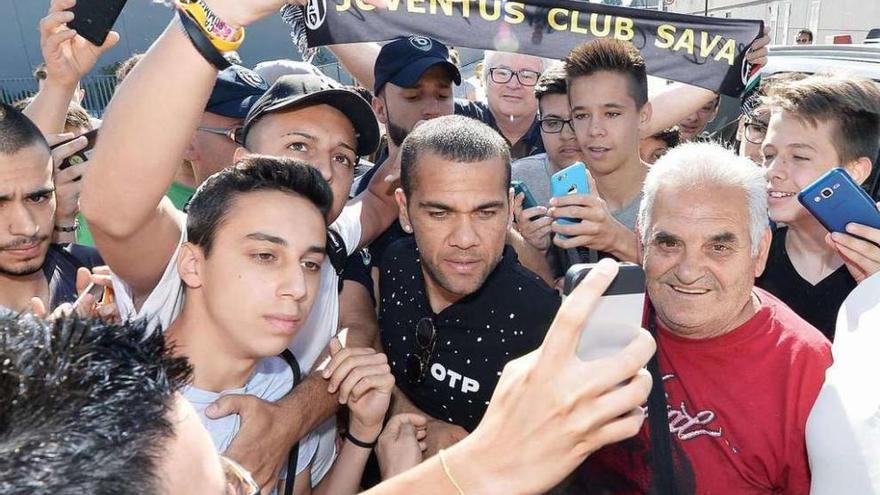 Alves posa con varios aficionados que lo esperaban a las puertas del centro médico en Turín.