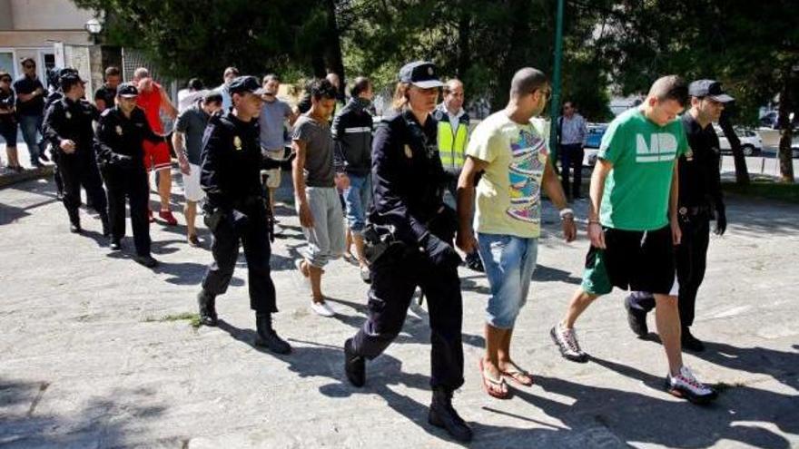Agentes de la Policía Nacional trasladan, en mayo de 2011, a los detenidos en la oficina de Palma desde la que se cometía la estafa.