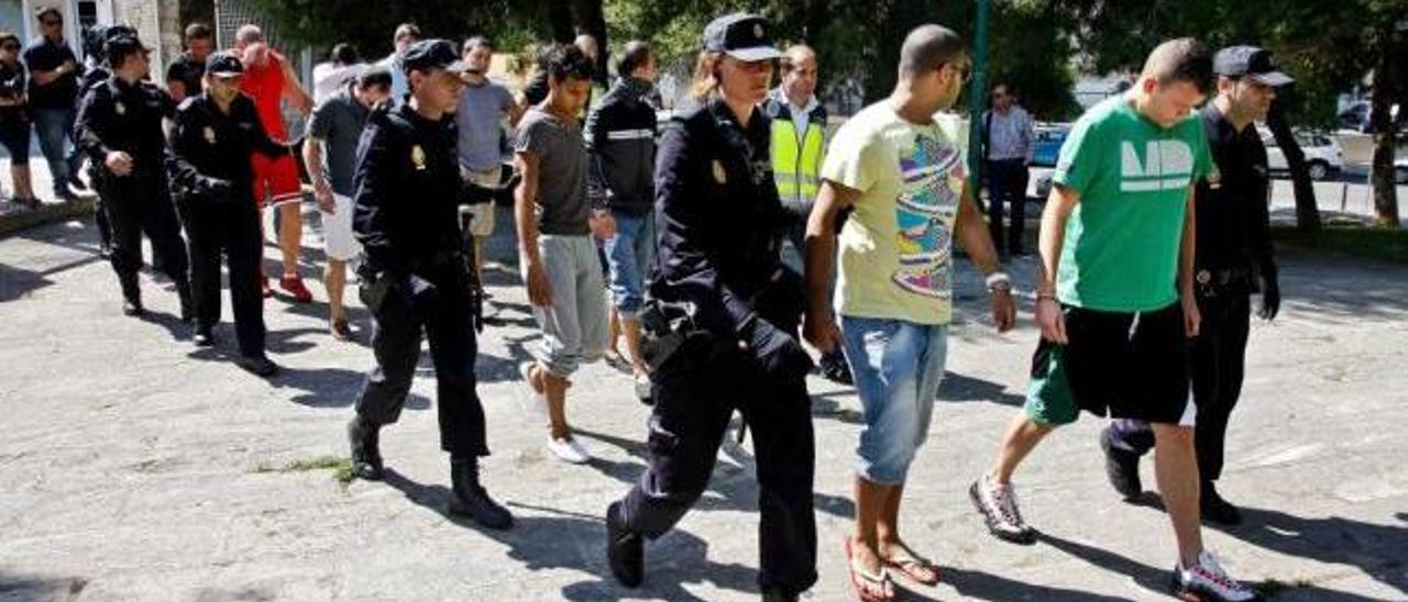 Agentes de la Policía Nacional trasladan, en mayo de 2011, a los detenidos en la oficina de Palma desde la que se cometía la estafa.