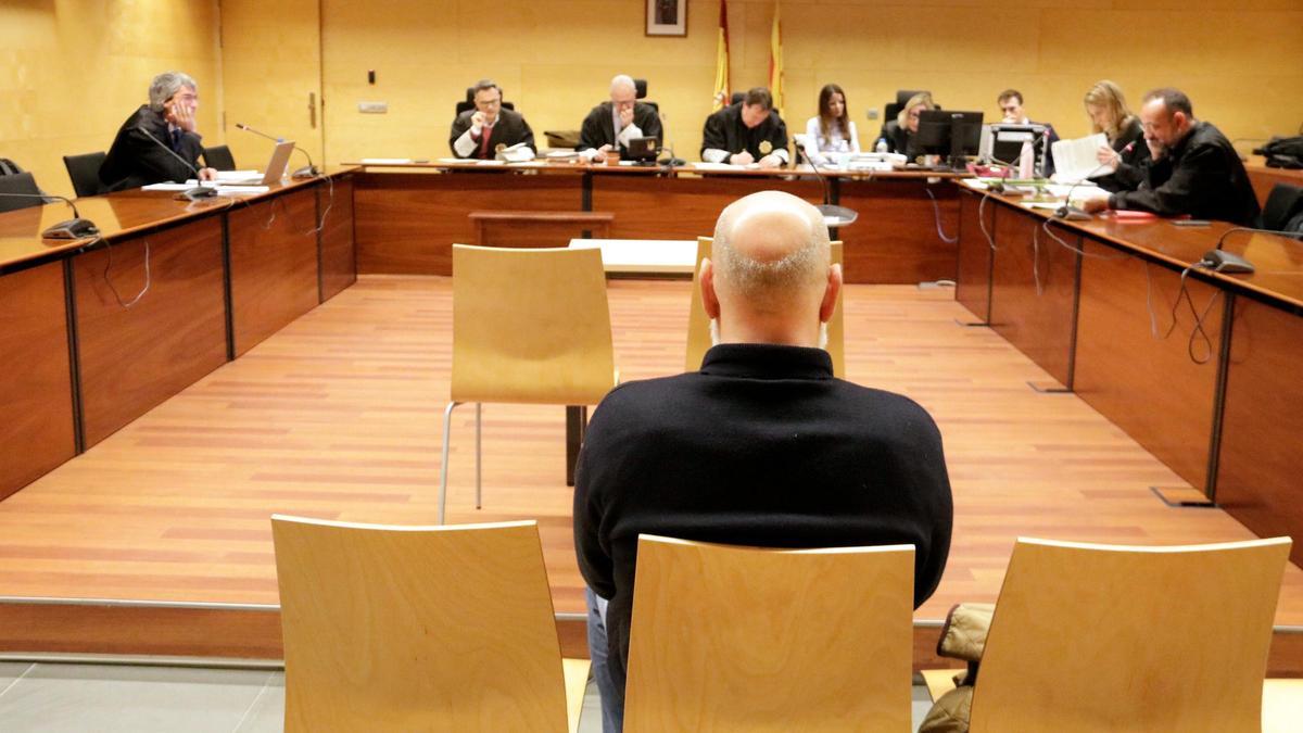 D'esquenes, l'acusat d'abusar sexualment d'una companya de feina a Girona. Foto del judici a l'Audiència