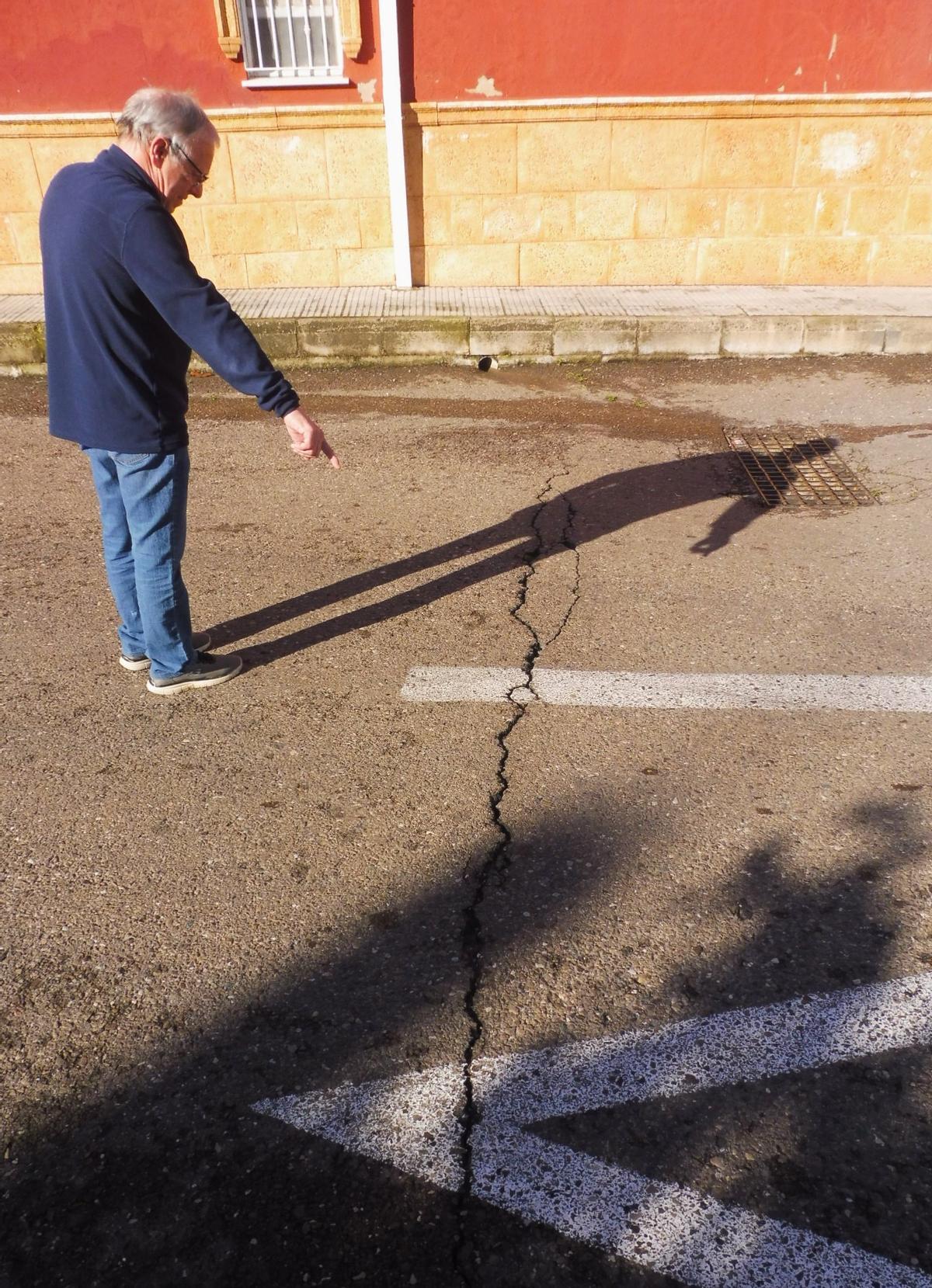 José Luis muestra una grieta en la calle causada por los camiones.