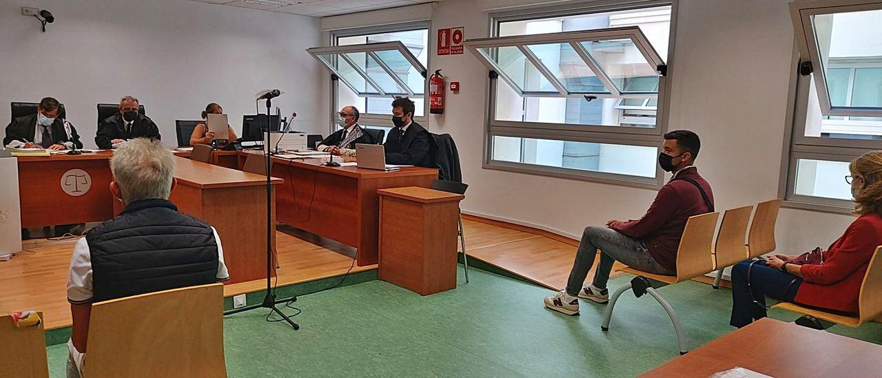 Los tres acusados sentados de espaldas en el banquillo al inicio del juicio. |