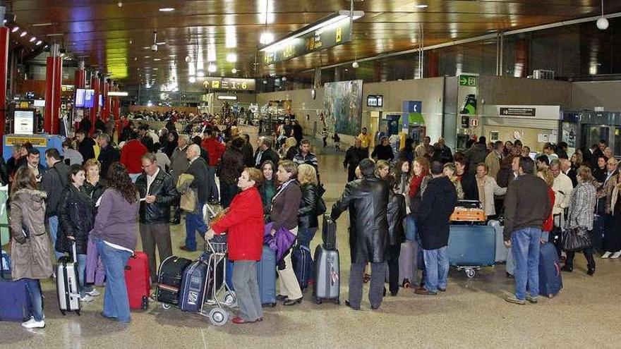 Decenas de pasajeros esperan a facturar sus equipajes en el aeropuerto de Peinador, el domingo 5 de diciembre. // Marta G. Brea