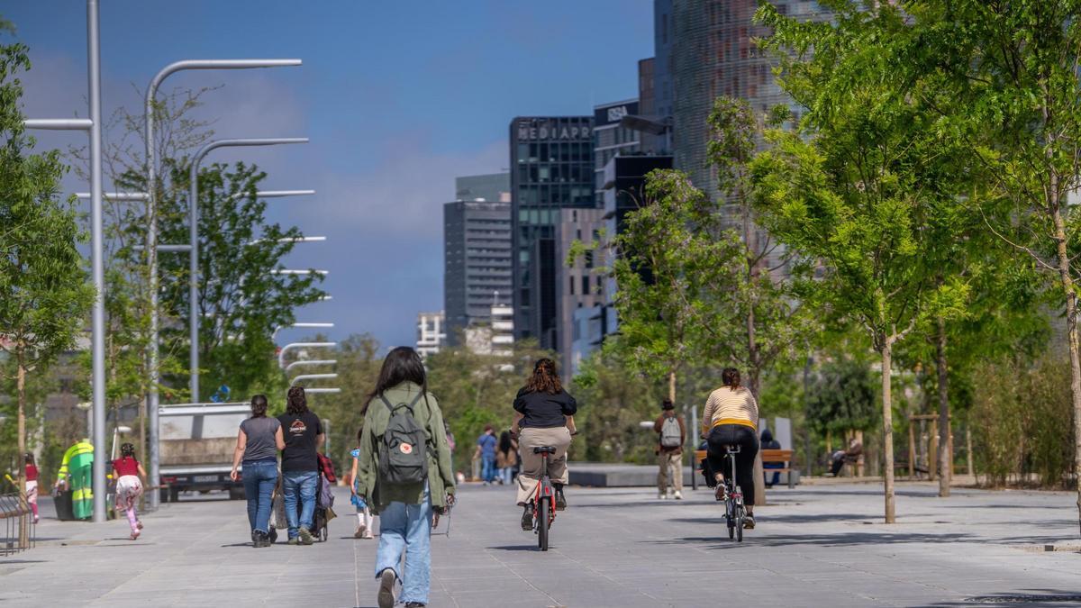 Peatones y ciclistas, en el paseo central del parque.