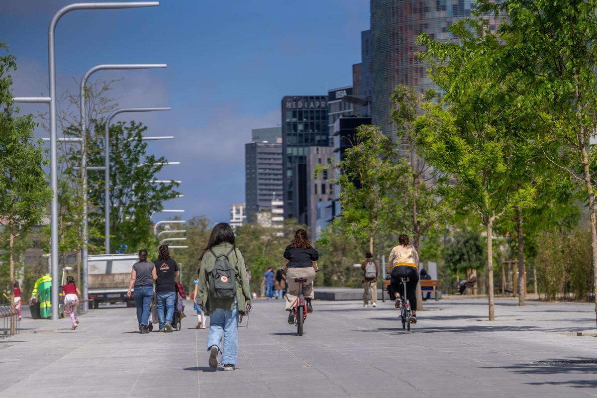 Peatones y ciclistas, en el paseo central del parque.