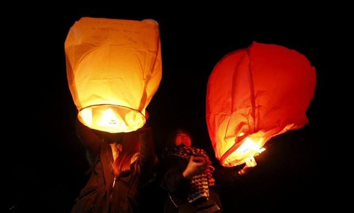 Els sud-coreans llancen fanalets al cel per demanar desitjos per al nou any, a la platja de Gangneung.