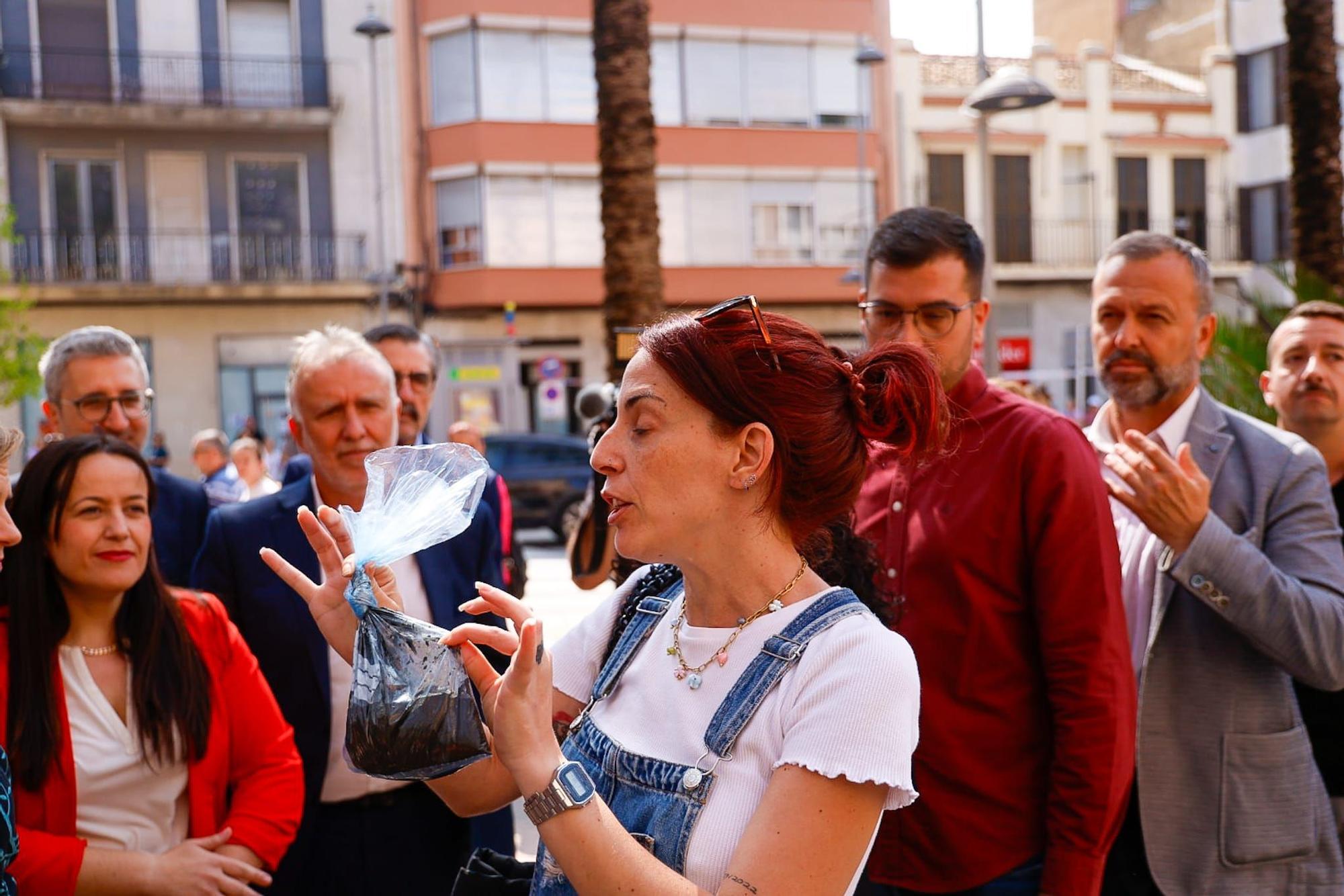 Una vecina de Catarroja lleva una bolsa de fango de la dana a la visita del ministro y Bernabé