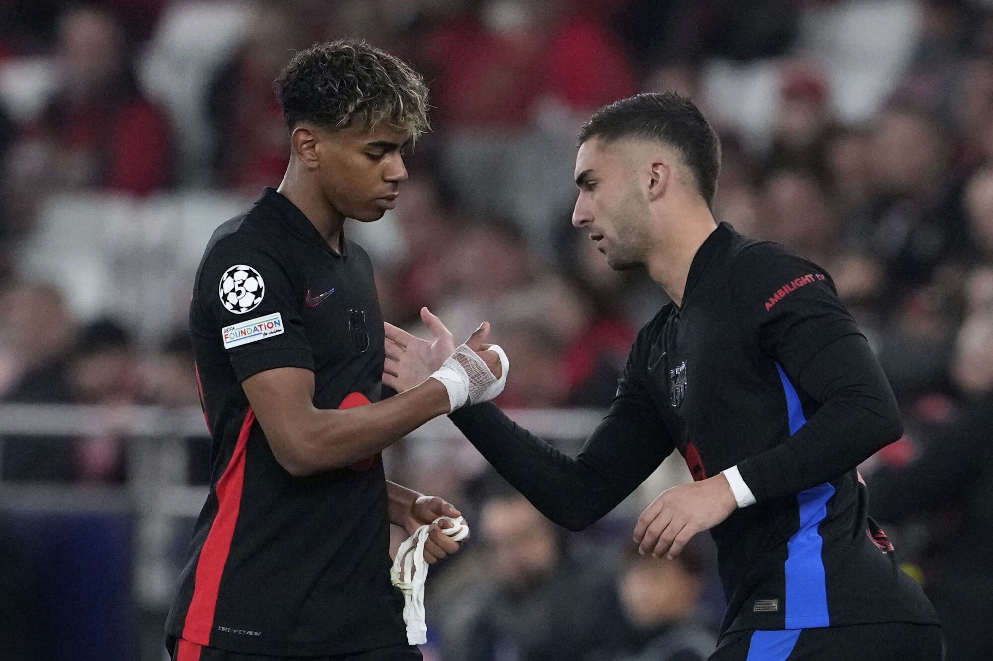Barcelona's Lamine Yamal, left, gestures as he is substituted by Barcelona's Ferran Torres during the Champions League round of 16 first leg soccer match between SL Benfica and FC Barcelona at the Luz stadium in Lisbon, Wednesday, March 5, 2025. (AP Photo/Armando Franca). EDITORIAL USE ONLY / ONLY ITALY AND SPAIN
