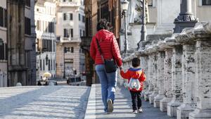 jmexposito53020811 rome  italy   03 04 2020   a woman and a child walk holding 200404110417