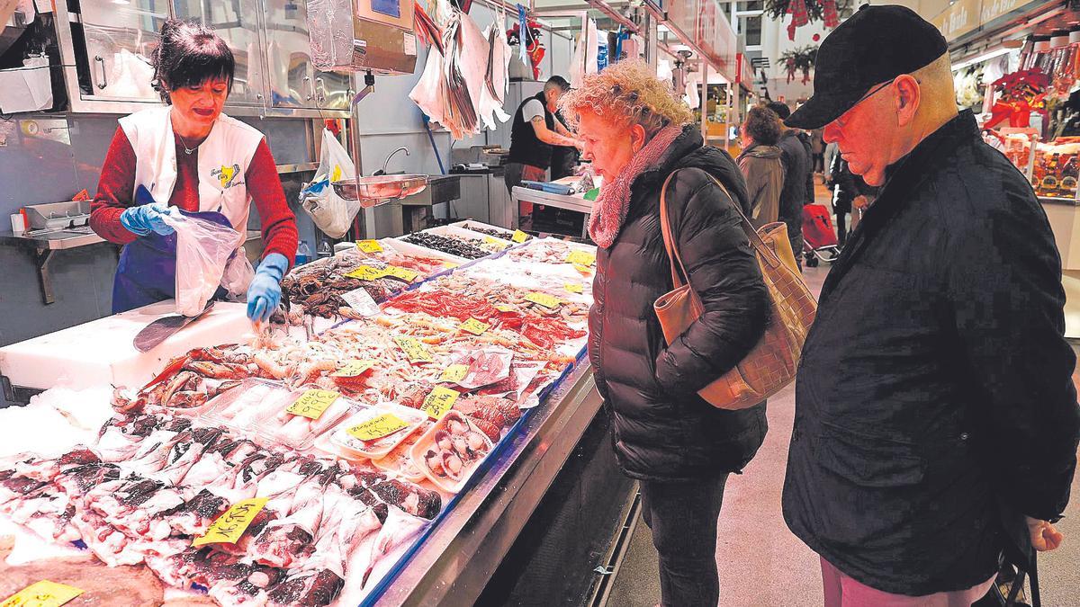 Dues persones comprant per a les festes nadalenques al Mercat del Lleó de Girona