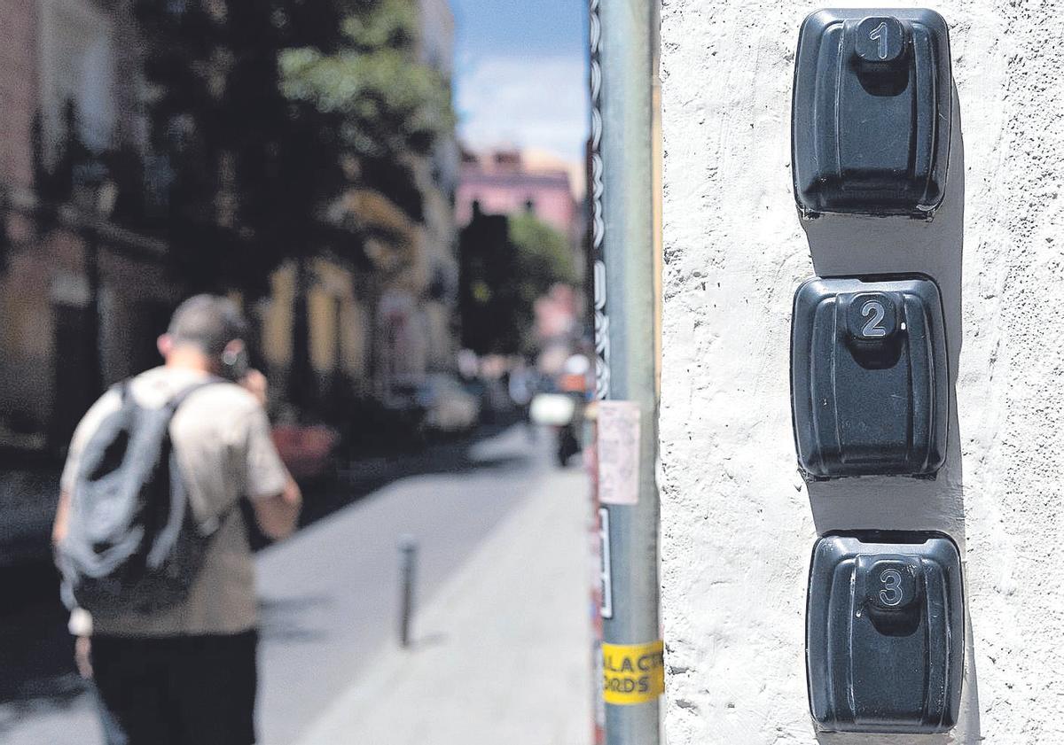 Una persona pasa junto al portal de unos apartamentos turísticos, con los cajetines de las llaves, en una imagen de archivo.