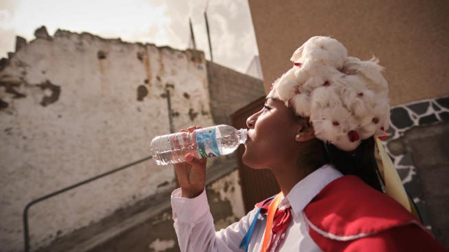 Una mujer bebe agua durante la romería de ayer de Arafo.